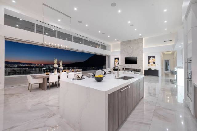 The kitchen displays a timeless motif with predominantly white cabinetry, contrasted by lower w ...